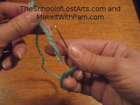 Hold needle point up and thread end down