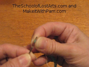 Eye of the needle lined up with the folded thread